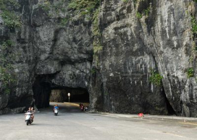 Skútry projíždějící přírodním tunelem na ostrově Green Island